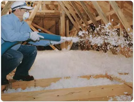 Insulation installer using spray foam to fill in the floor of an attic